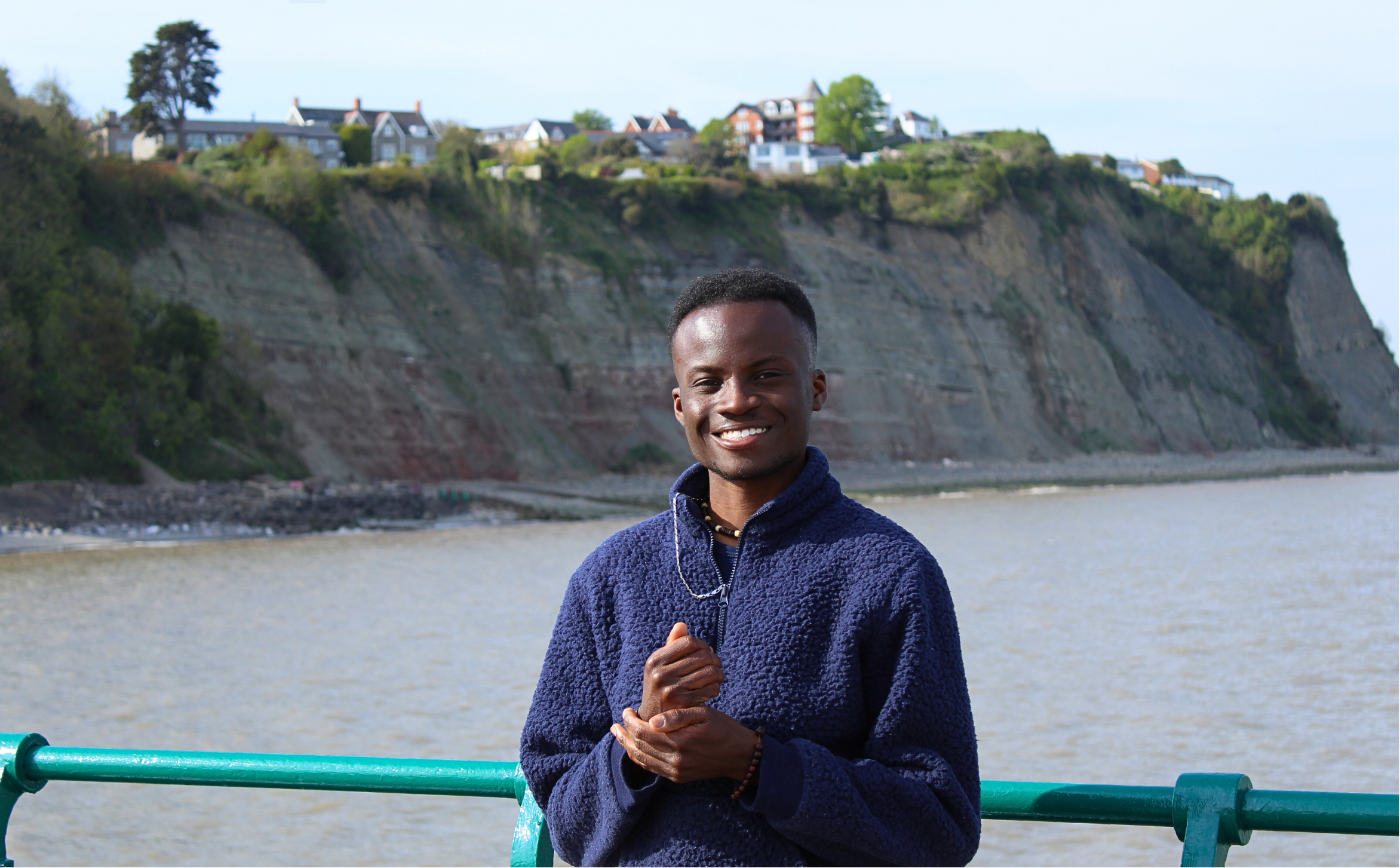 Adjei standing on bridge near a body of water