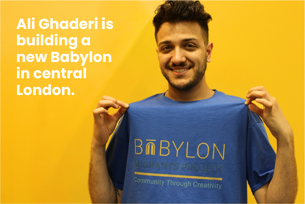 Ali Ghaderi holding up his shirt Text on shirt - Babylon. Migrants Project. Community Through Creativity. 