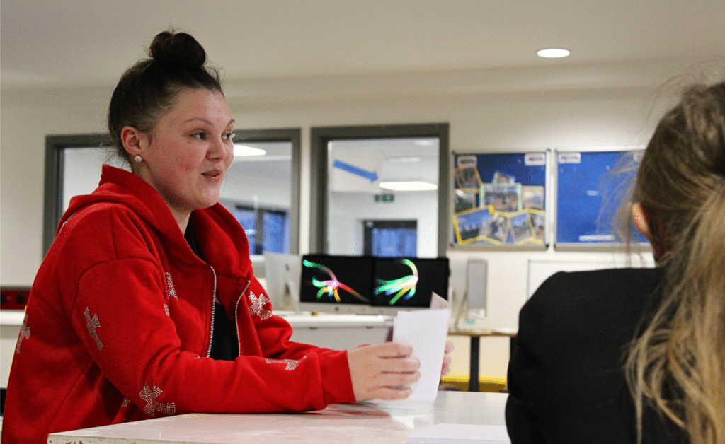 A person sitting at a table with a person in a red jacket