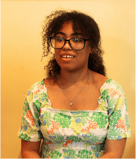 A person wearing glasses and a floral dress