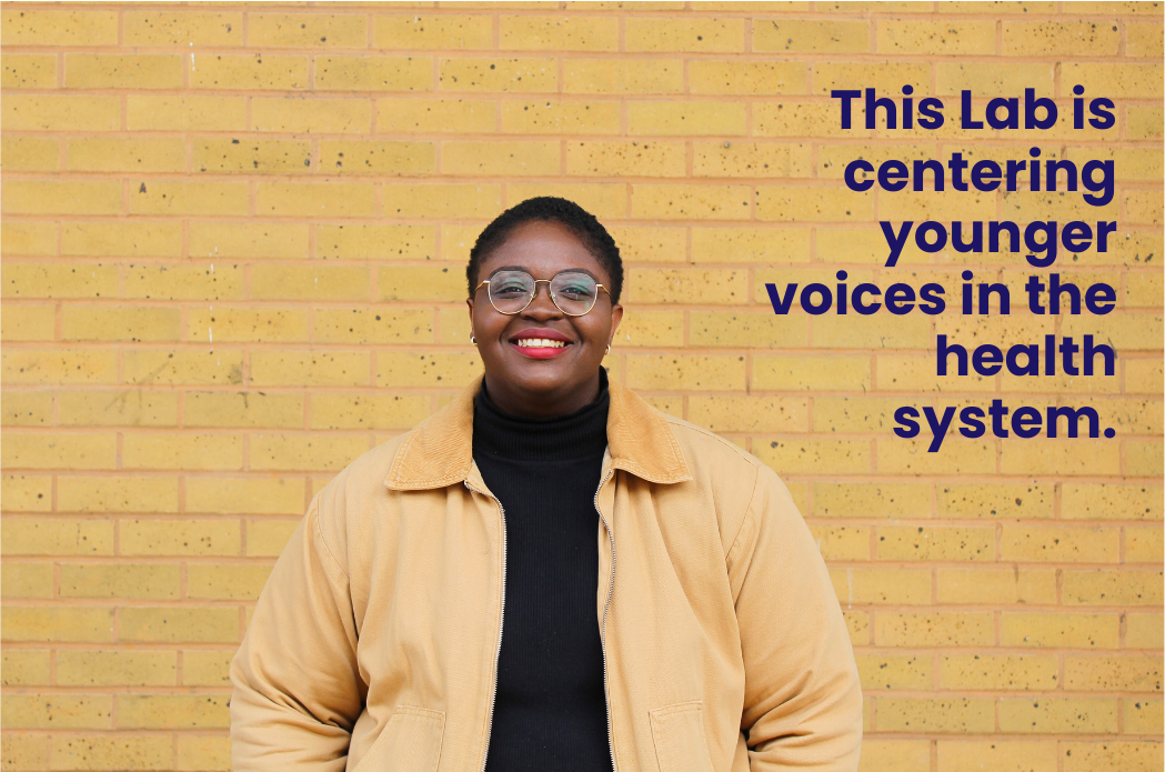 Fola Afolabi smiling in front of a beige brick wall. Text in picture: This Lab is centring younger voices in the health system.