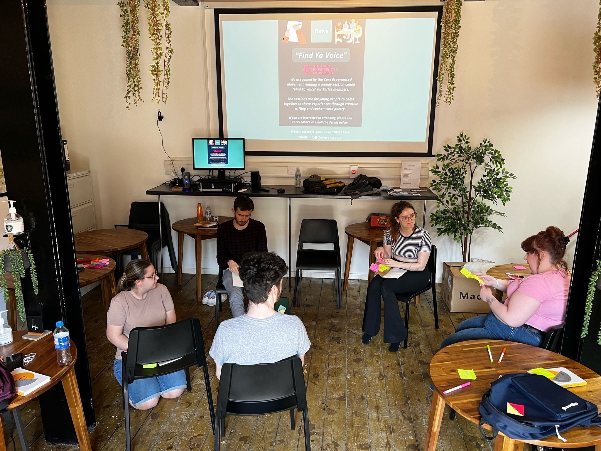 A group of 5 people sitting together having a discussion