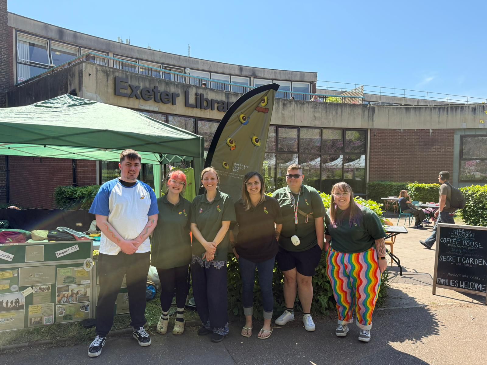 6 people taking a picture infront of their companies banner